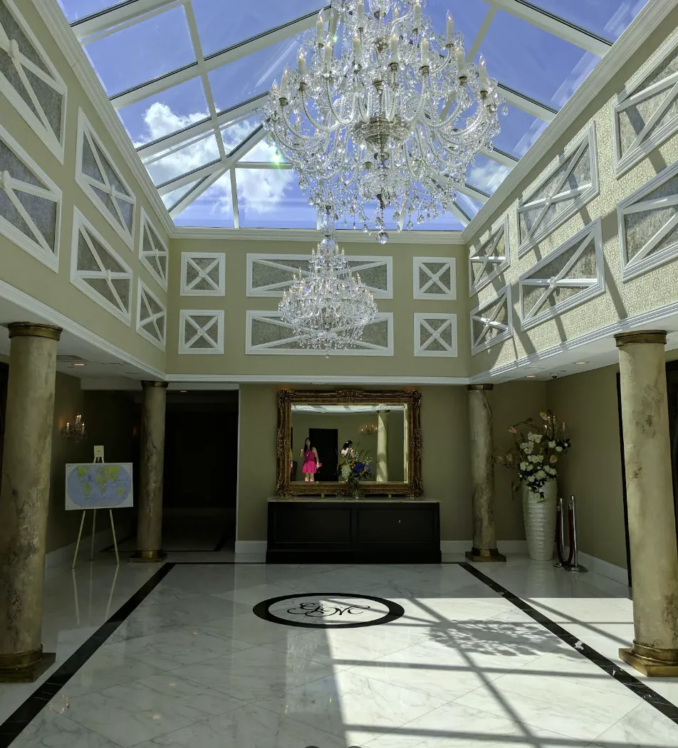 Marble entry atrium with crystal chandeliers and skylight