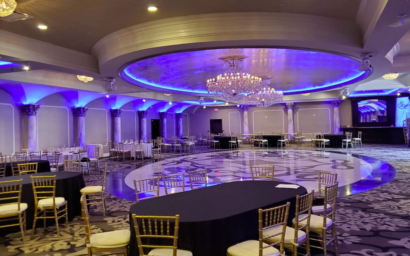 Grand ballroom with columns, illuminated dome, and polished dance floor