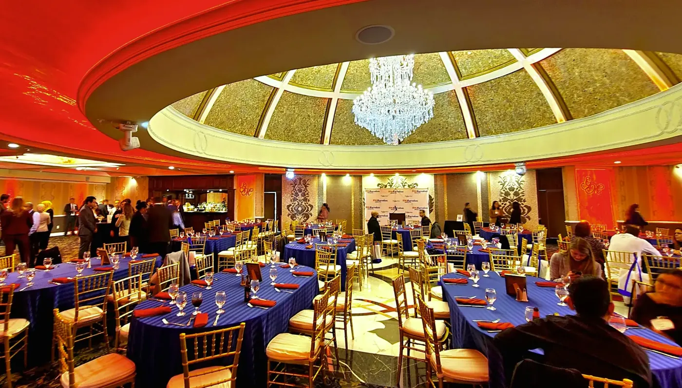Guests seated at banquet tables beneath the domed chandelier ballroom